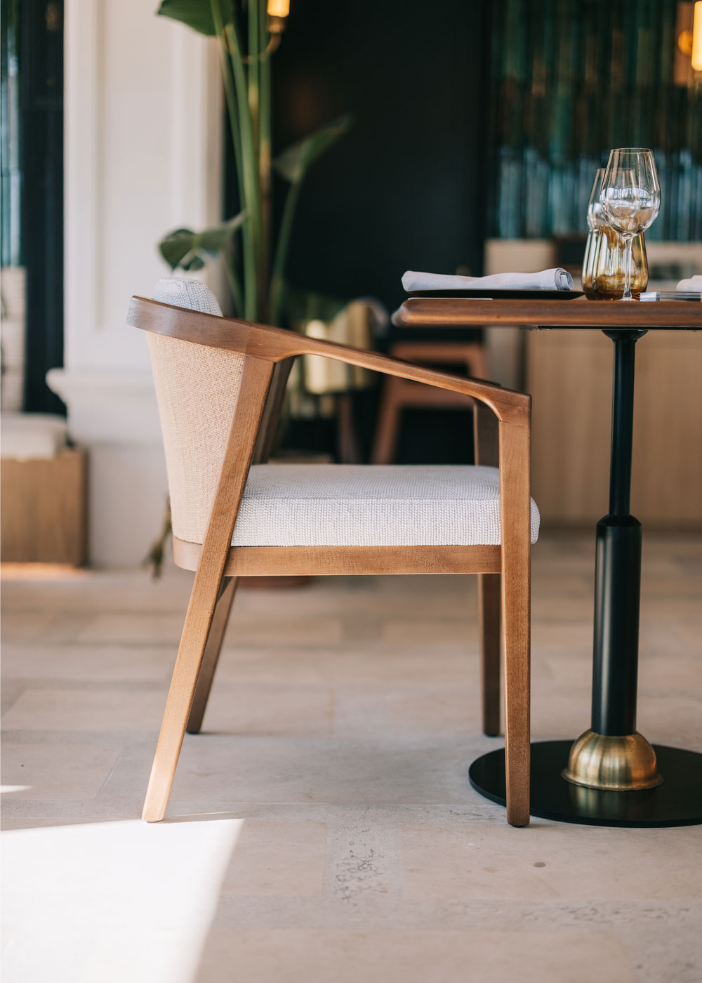 Silla de madera con reposabrazos tapizada en beige