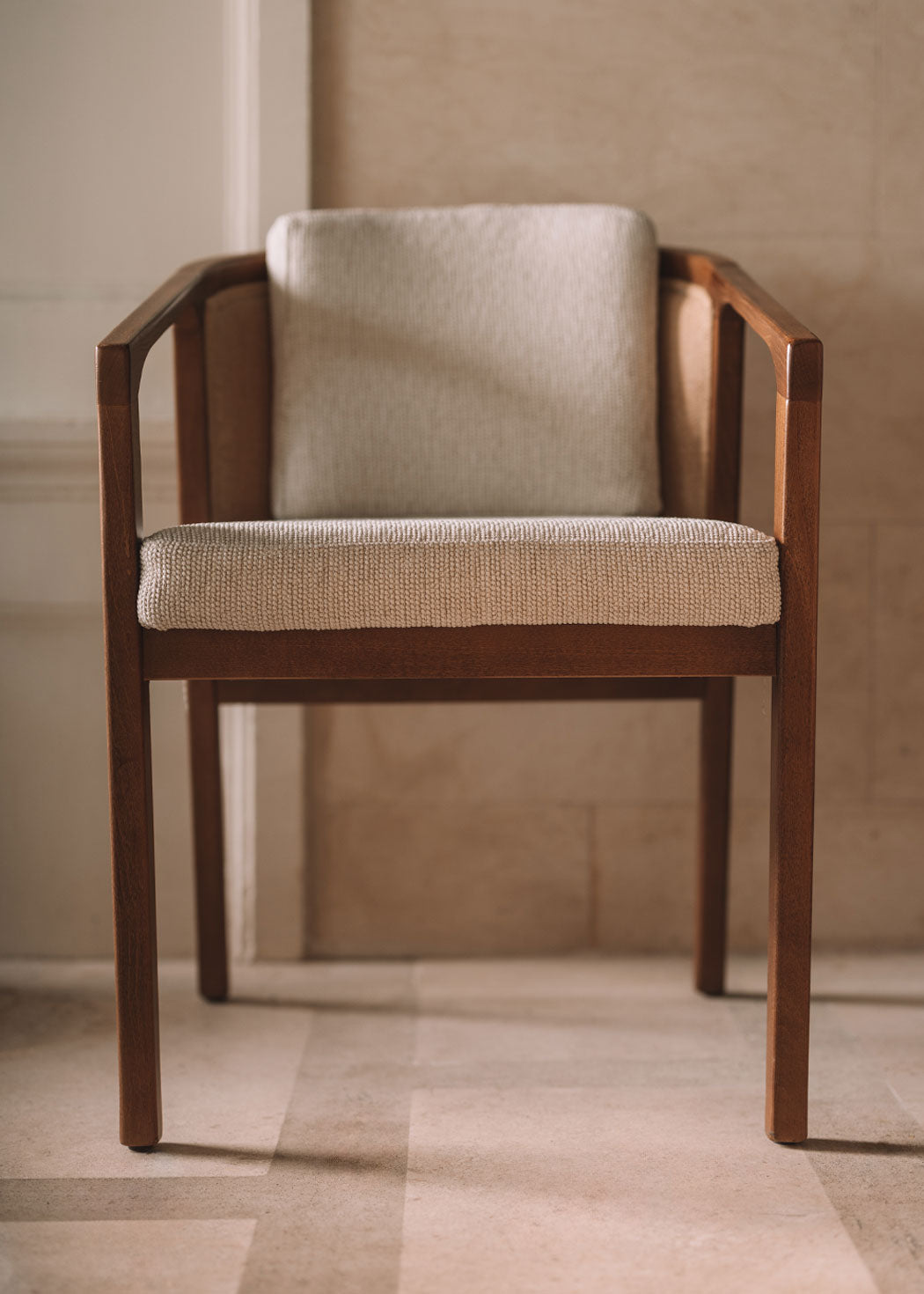 Silla de madera de haya con reposabrazos tapizada con una tela con textura en color beige