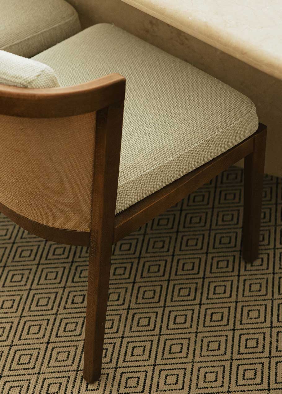 Silla de madera de haya tapizada en tela beige.