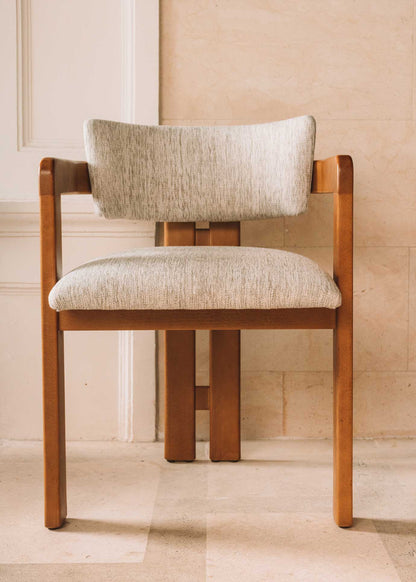 Silla de madera de haya con reposabrazos tapizada en tela jaspeada.