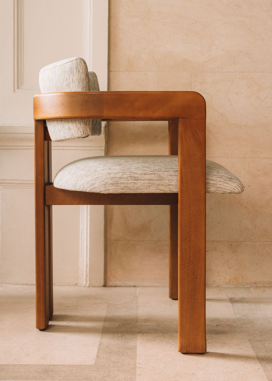 Silla de madera de haya con reposabrazos tapizada en tela jaspeada.