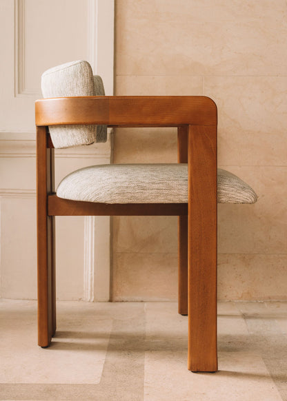 Silla de madera de haya con reposabrazos tapizada en tela jaspeada.