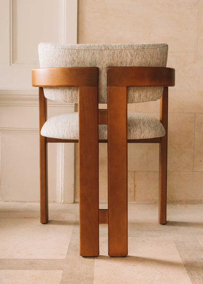 Silla de madera de haya con reposabrazos tapizada en tela jaspeada.