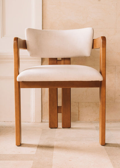 Silla de madera de haya con reposabrazos tapizada en terciopelo beige.