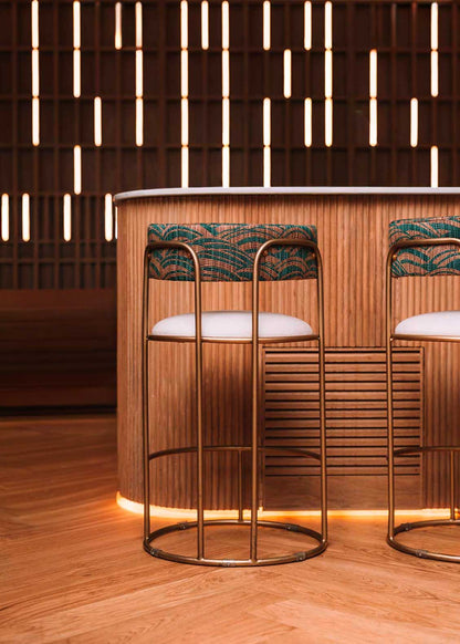 Taburete tapizado con estructura de hierro.