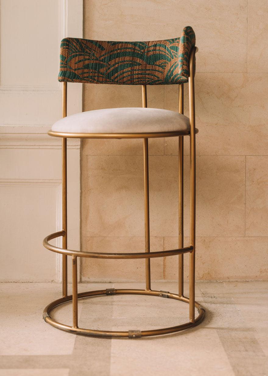 Taburete tapizado con estructura de hierro.