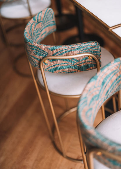 Taburete tapizado con estructura de hierro.