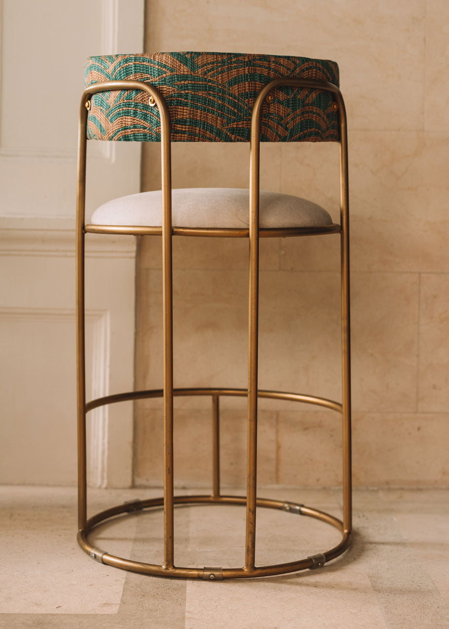 Taburete tapizado con estructura de hierro.