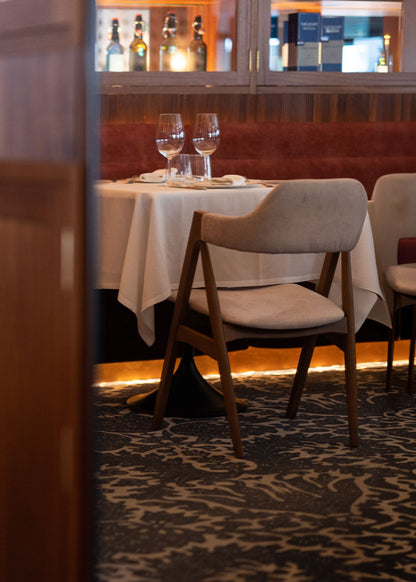 Silla con estructura de madera de haya tapizada en terciopelo beige.