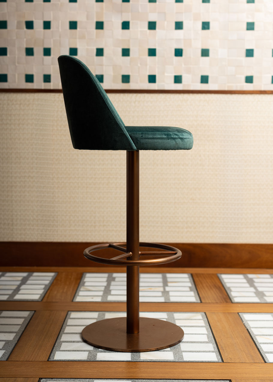 Taburete tapizado con estructura de hierro acabado en oro rosa.