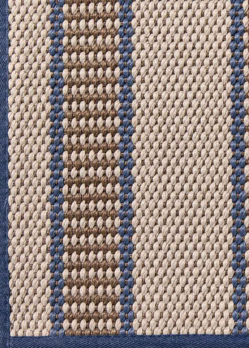 Alfombra fabricada en PET a partir de botellas de plástico recicladas de color beige con detalles en azul y elaborada en telar wilton de tejido plano.
