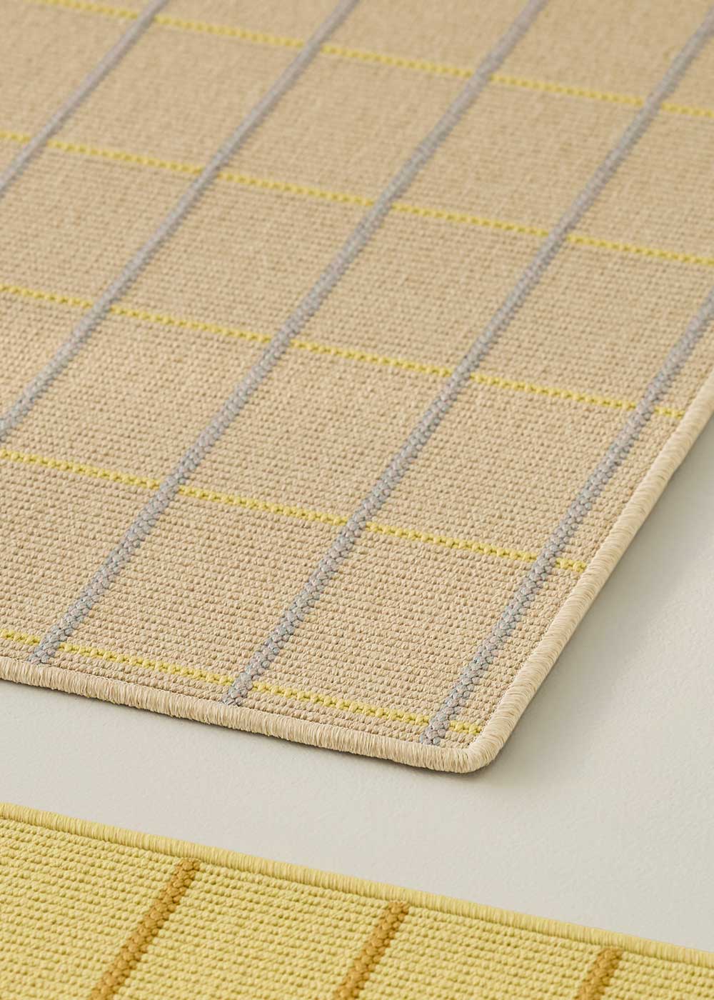 Alfombra fabricada en PET a partir de botellas de plástico recicladas de color beige en telar wilton de tejido plano.
