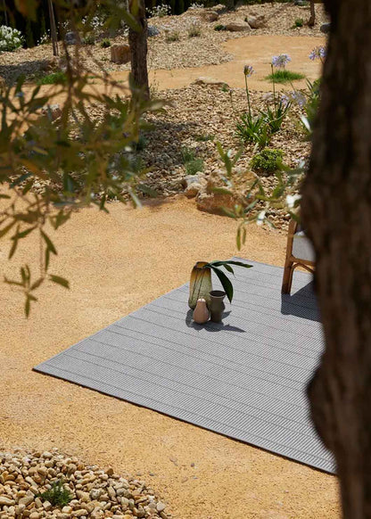 Alfombra fabricada en PET a partir de botellas de plástico recicladas de color gris en telar wilton de tejido plano.