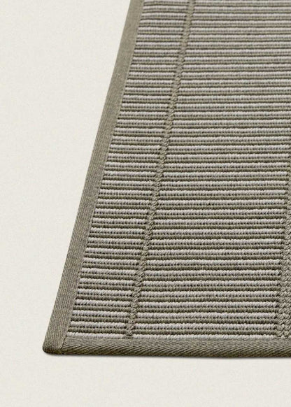 Alfombra fabricada en PET a partir de botellas de plástico recicladas de color gris en telar wilton de tejido plano.