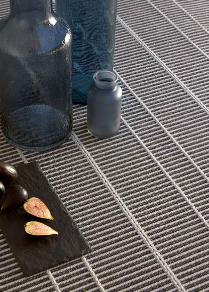 Alfombra fabricada en PET a partir de botellas de plástico recicladas de color gris azulado en telar wilton de tejido plano.