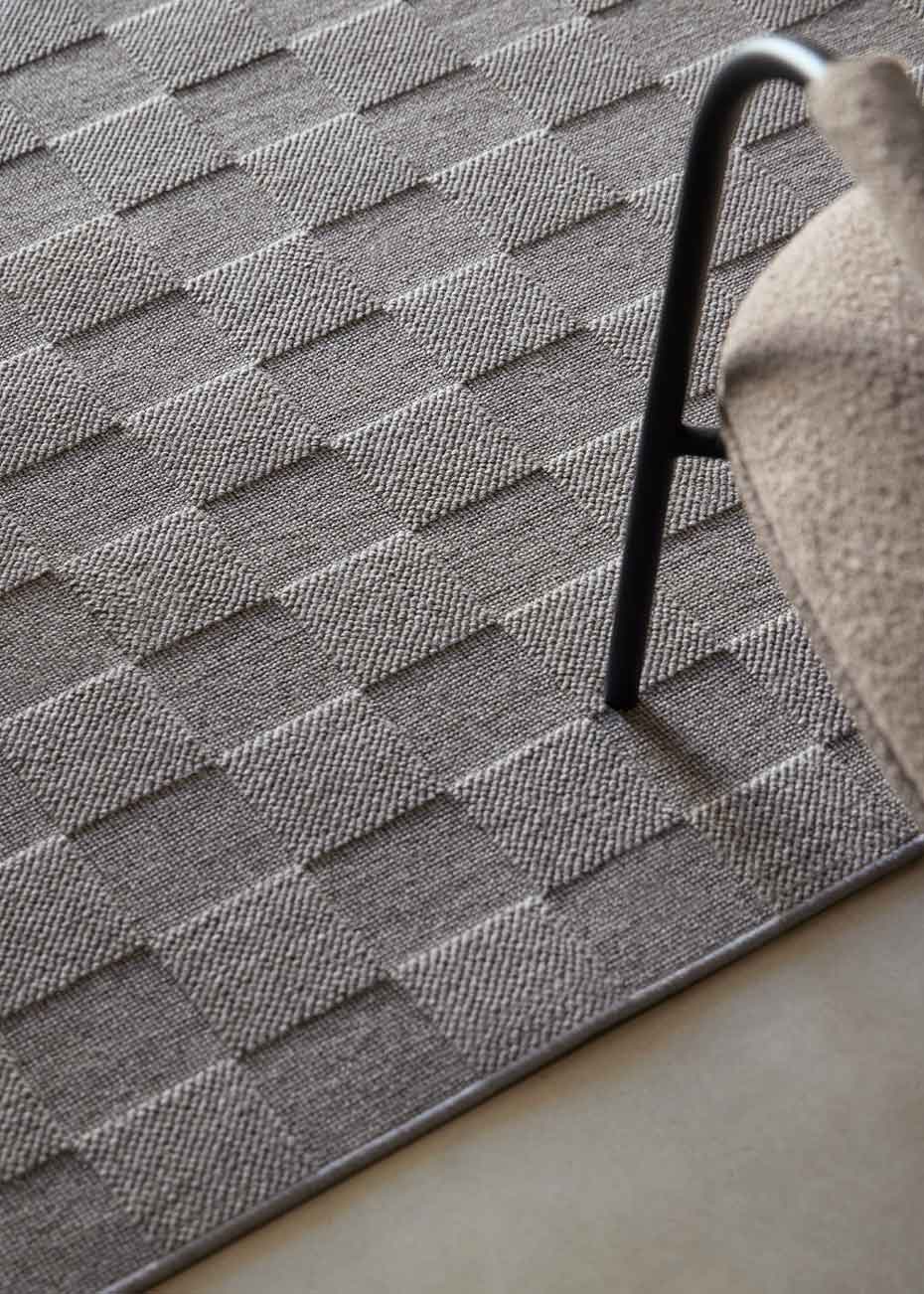 Alfombra fabricada con lana de color gris en telar wilton con superficie en bucle con saltillo.