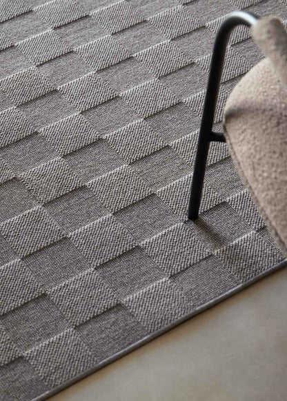 Alfombra fabricada con lana de color gris en telar wilton con superficie en bucle con saltillo.