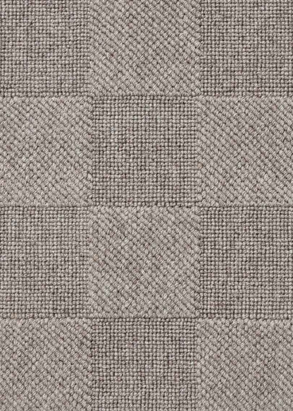Alfombra fabricada con lana de color gris en telar wilton con superficie en bucle con saltillo.