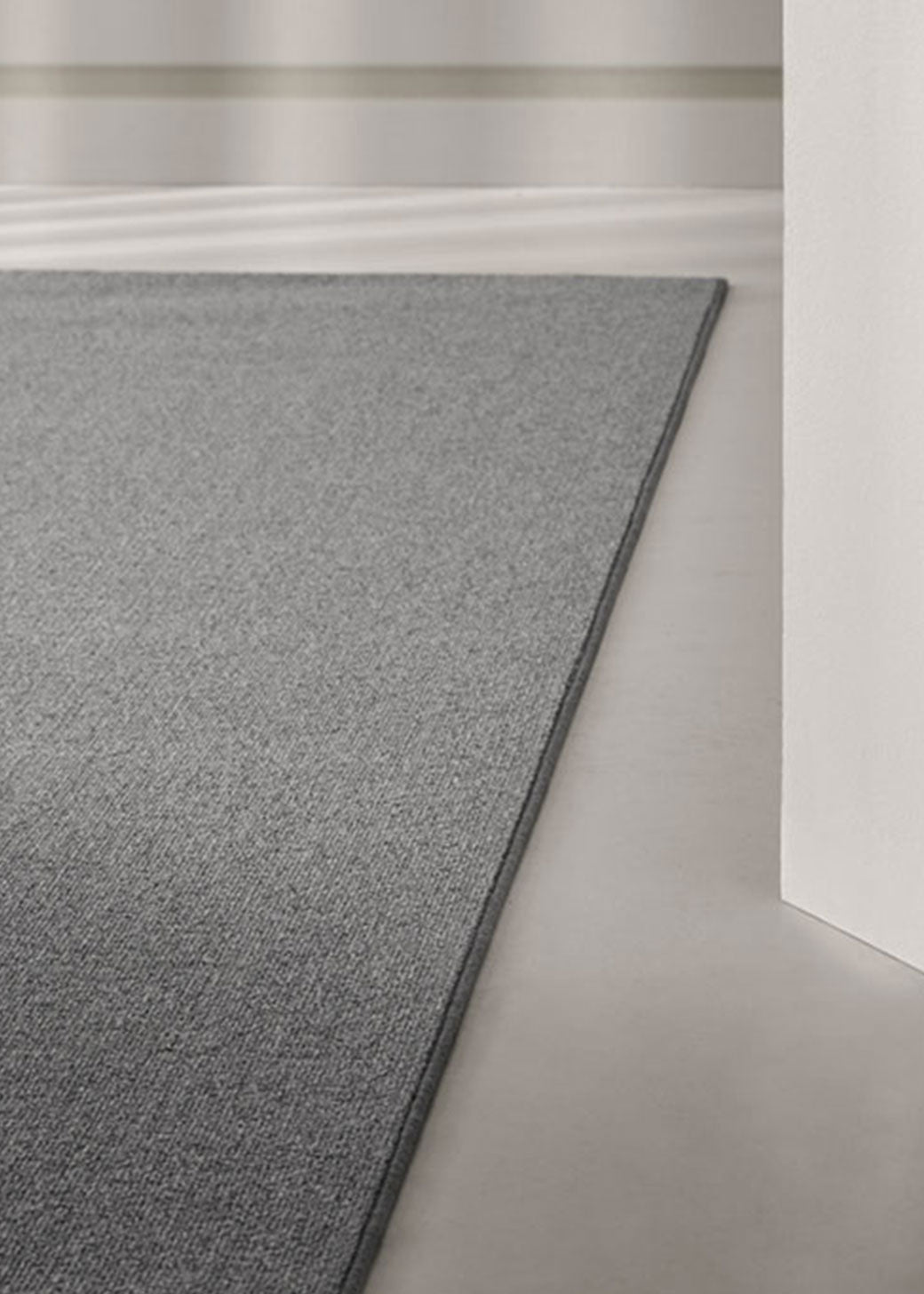Alfombra fabricada con lana de color gris en telar tufting con superficie en bucle.