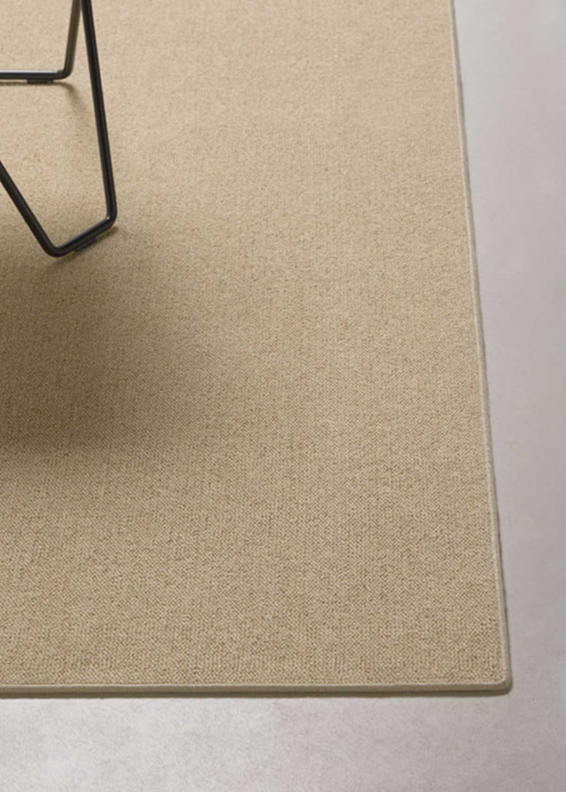 Alfombra fabricada con lana de color beige en telar tufting con superficie en bucle.