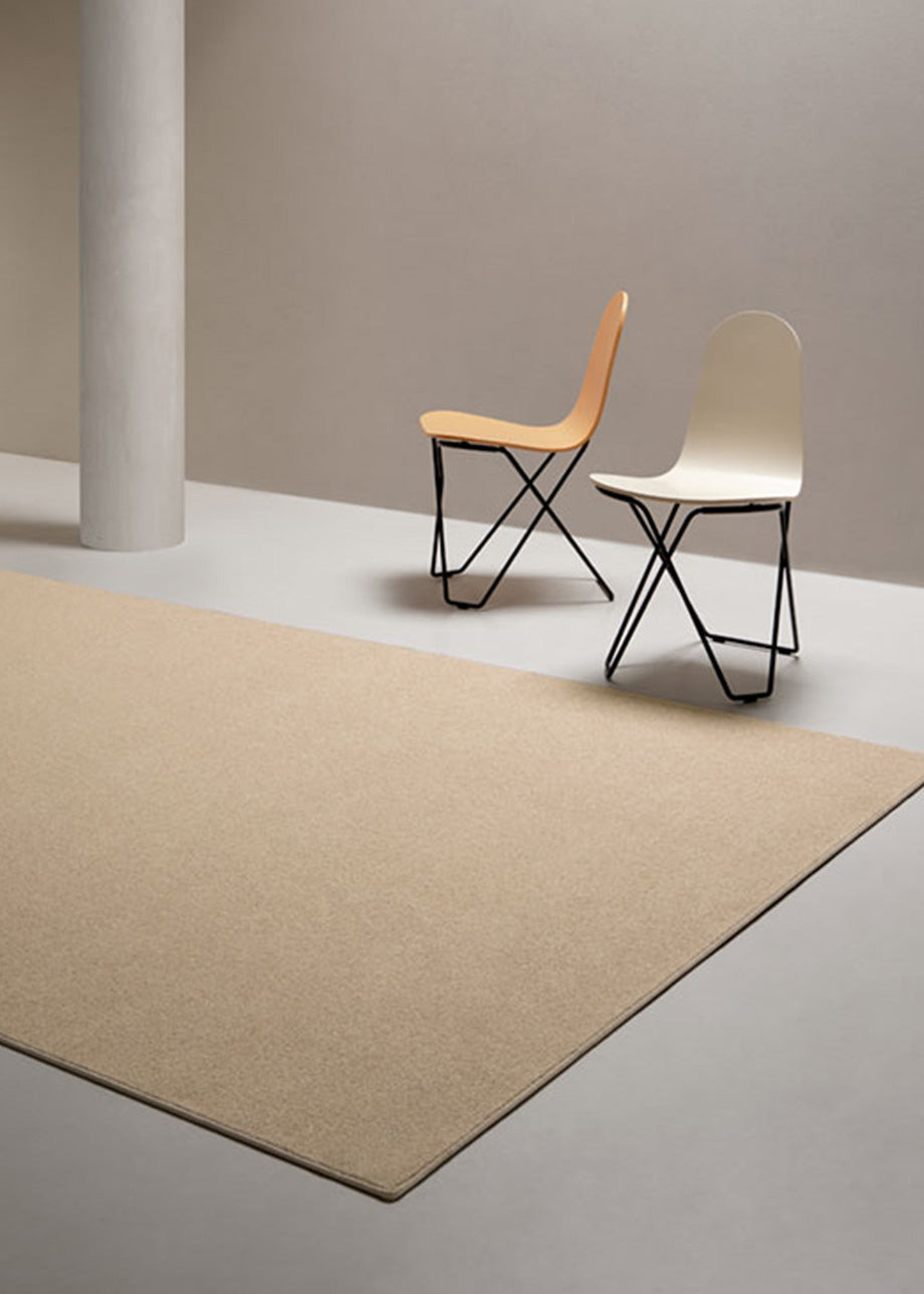 Alfombra fabricada con lana de color beige en telar tufting con superficie en bucle.