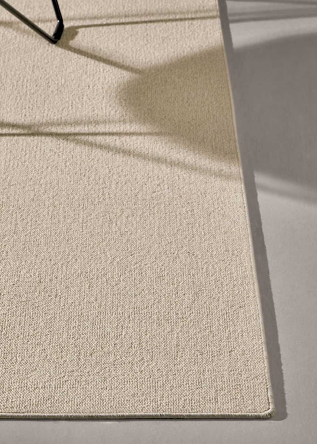 Alfombra fabricada con lana de color vainilla en telar tufting con superficie en bucle.