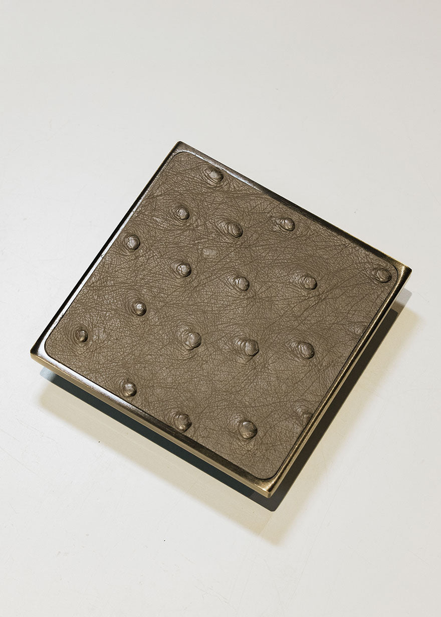 Square metal handle covered in ostrich leather