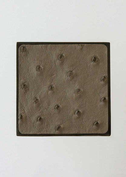 Square metal handle covered in ostrich leather