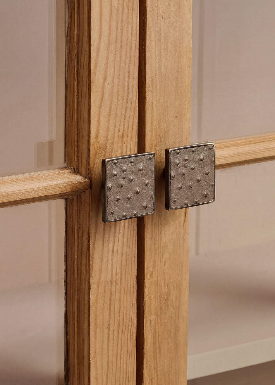 Square metal handle covered in ostrich leather