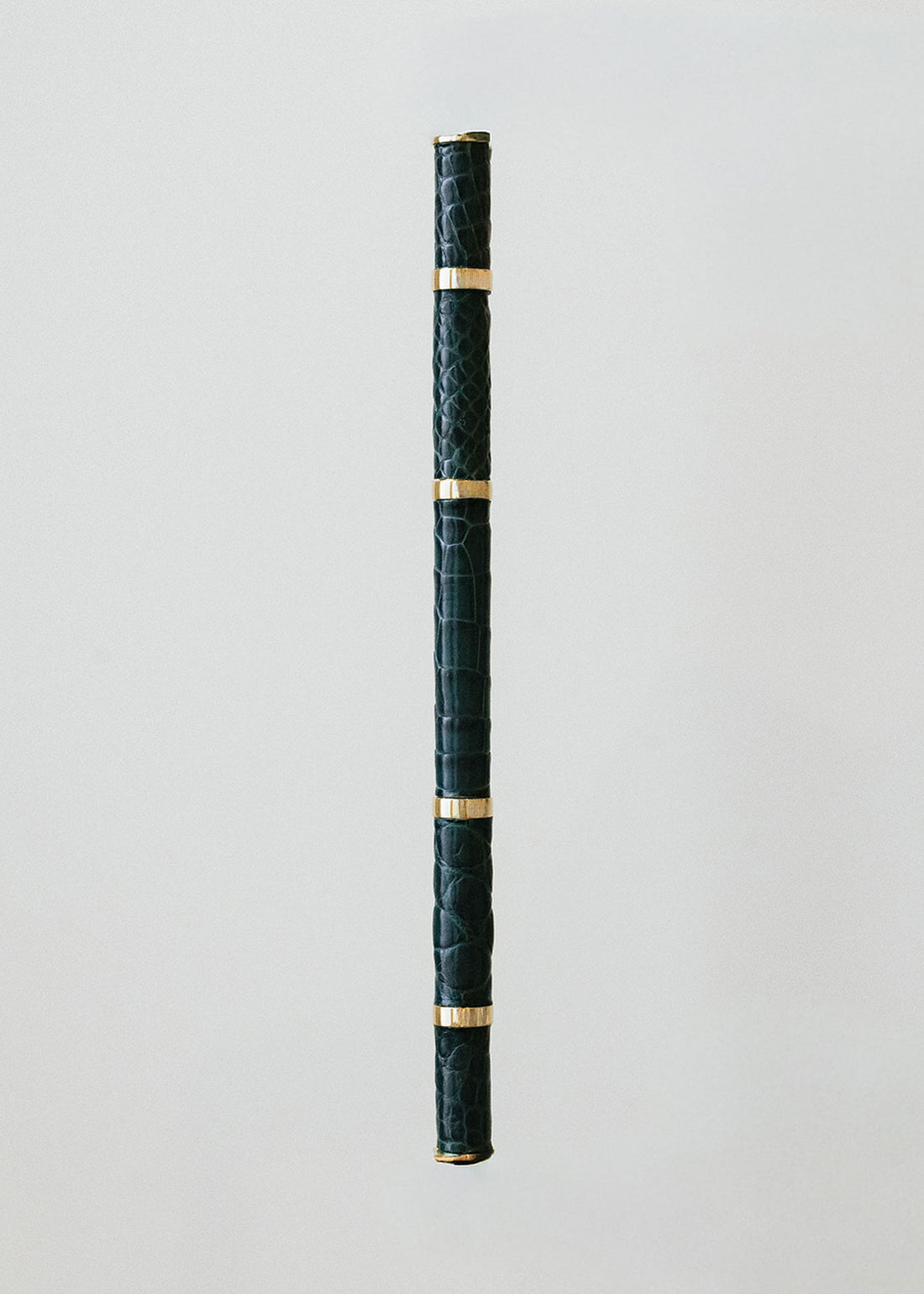 Metal handle wrapped in crocodile skin