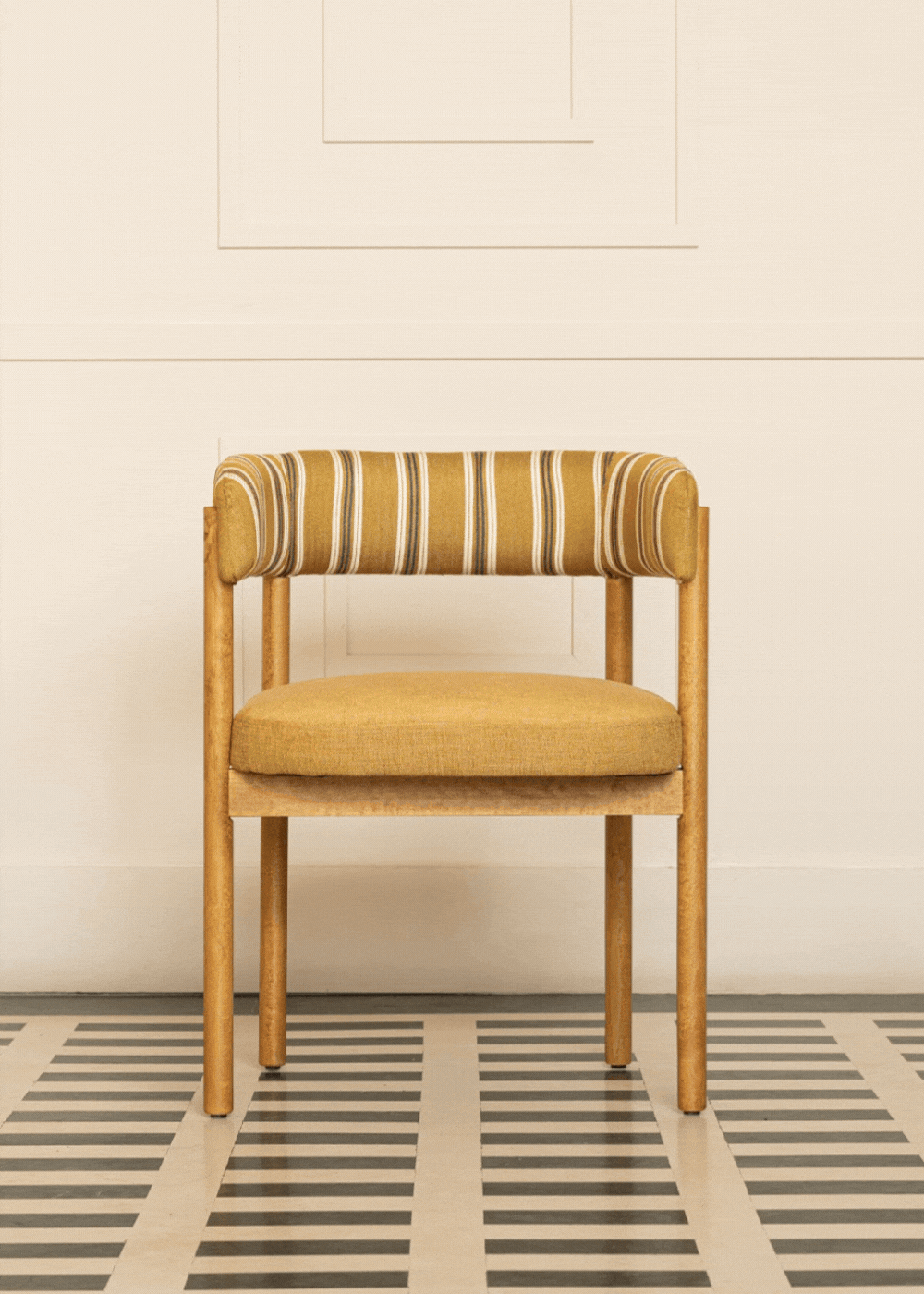 Silla de madera de haya con reposabrazos, asiento tapizado en tela mostaza y respaldo con estampado de rayas.